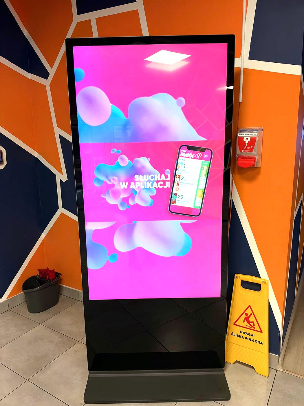 Telewizor 65" pionowy z reklamą aplikacji