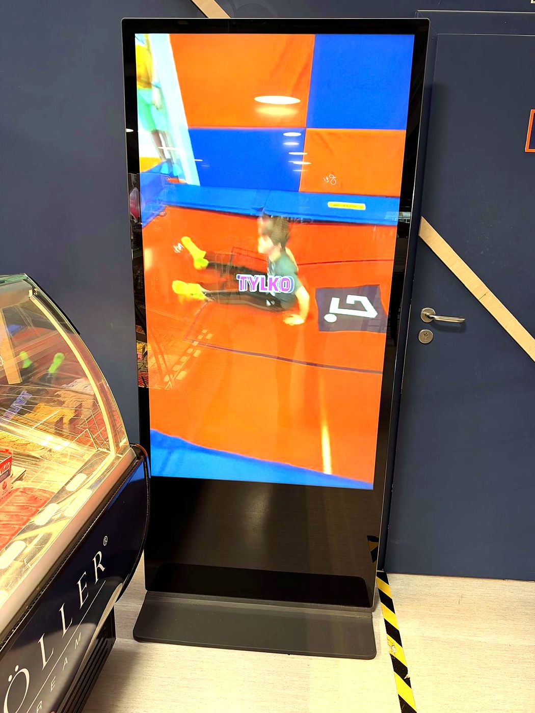 Telewizor 65" pionowy przy kawiarni